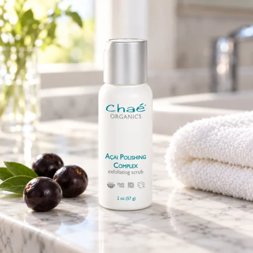 Chaé Açai Polishing Complex (Exfoliating Scrub) on a marble vanity with açai berries and a folded towel