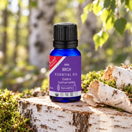 Chaé Birch Essential Oil on a birch log slice with birch bark and moss