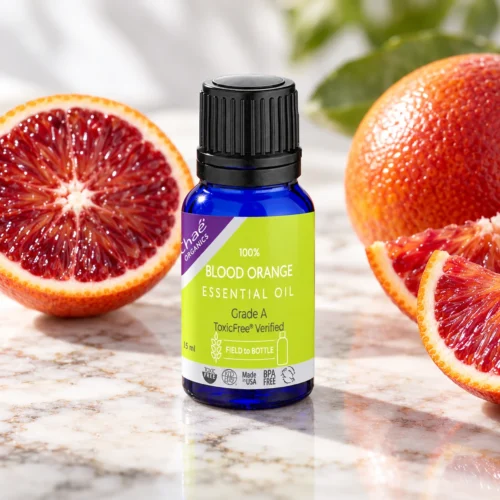 Chaé Blood Orange Essential Oil on marble beside sliced blood oranges