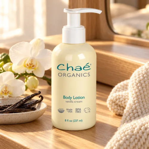 Chaé Body Lotion (Vanilla Cream) on a wooden vanity with vanilla pods and orchids