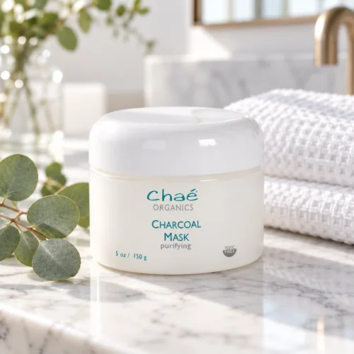 Chaé Charcoal Mask (Purifying) on a marble bathroom counter with a waffle towel and eucalyptus
