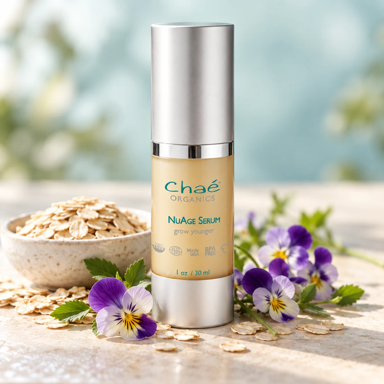 NuAge Peptide Serum with a few small purple wild pansy flowers and a small bowl of oats