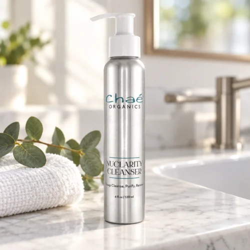 Chaé NuClarity Cleanser on a white marble bathroom counter with a folded face cloth and eucalyptus