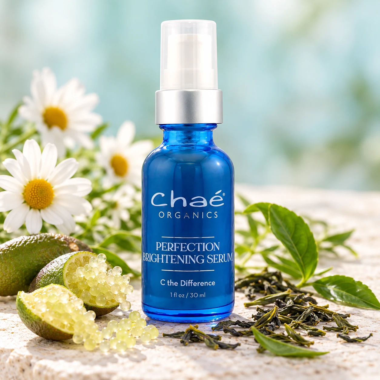 Perfection Brightening Serum with white daisies, a few split finger limes showing their pearls and a few loose green tea leaves