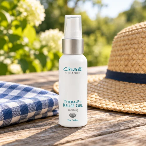 Chaé Thera-P Relief Gel (Soothe Bites & Burns) on a garden picnic table with a gingham napkin and a straw hat