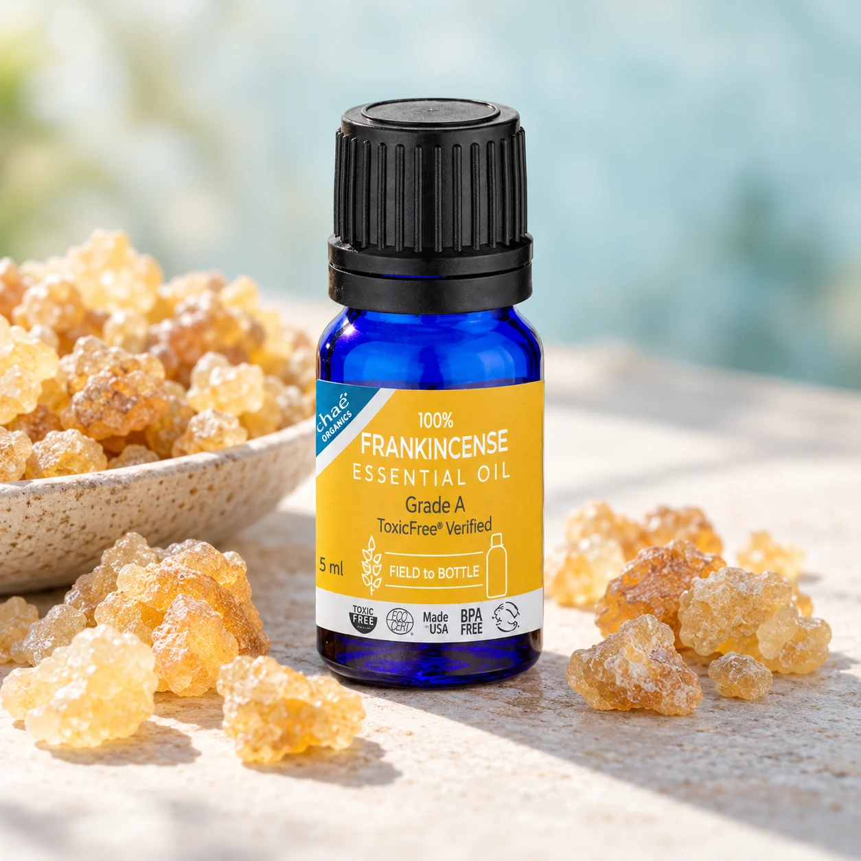 Frankincense Essential Oil with a small dish of golden frankincense resin tears