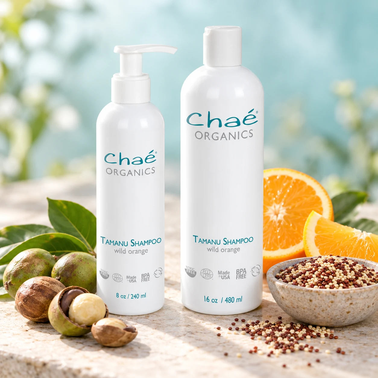 Tamanu Shampoo with a few tamanu nuts, a small bowl of quinoa seeds and orange slices