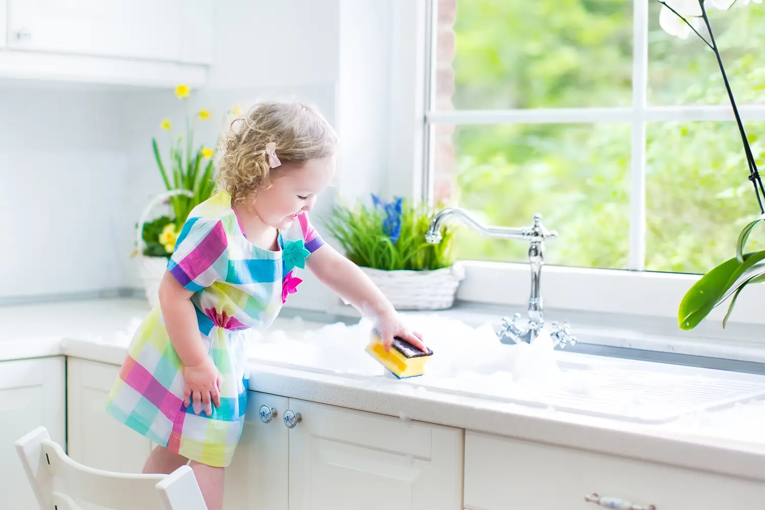 Little Girl washing dishes without gloves with safe toxicfree products